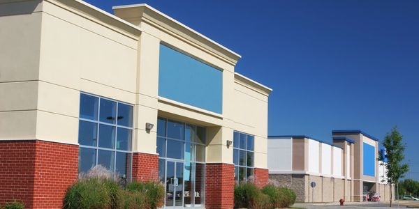 Empty shopping plaza with clear blue sky.