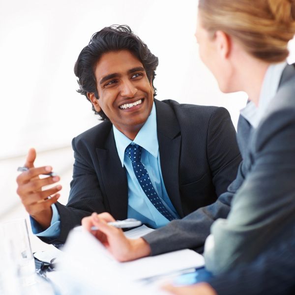 Two business professionals engaged in a friendly discussion during a meeting.