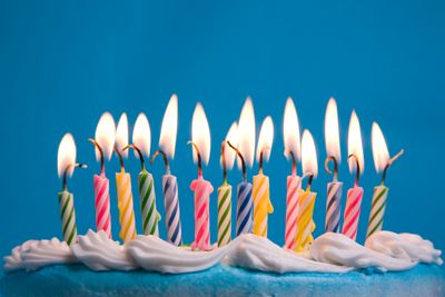 Lit birthday candles on cake icing.