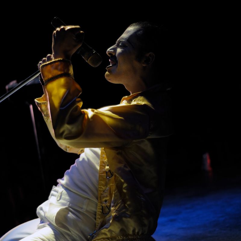 A young man is singing on stage.