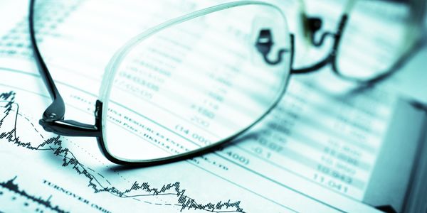 Glasses resting on a financial chart.