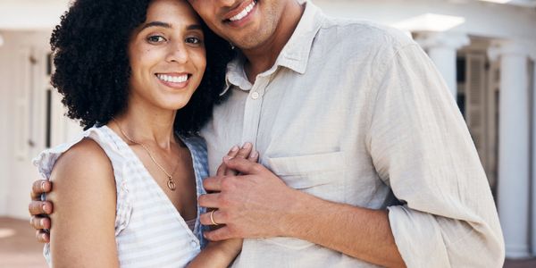 Smiling couple embracing lovingly outdoors.