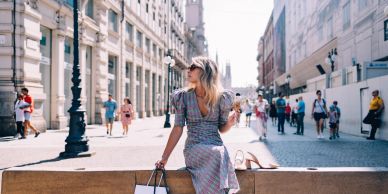 Woman sitting outdoors in a busy urban area.