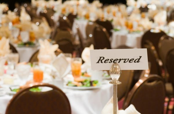 Elegant reserved corporate dining table with fresh plates and flowers  personalized event planning 