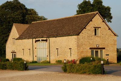 Stone building with wooden roof and greenery.