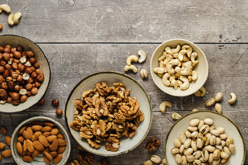 Healthy nuts based food snacks mix on wooden background.