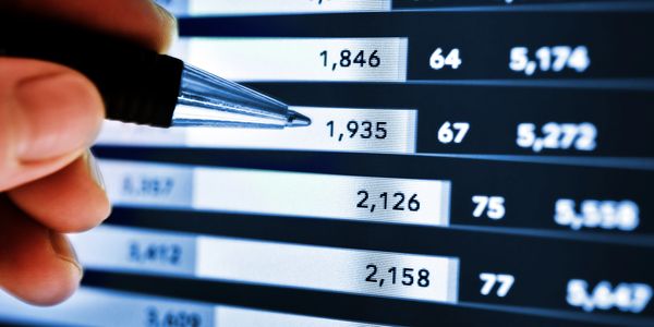 Hand pointing at data on a digital screen with a pen.