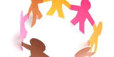 Colorful paper cutouts of people holding hands in a circle.