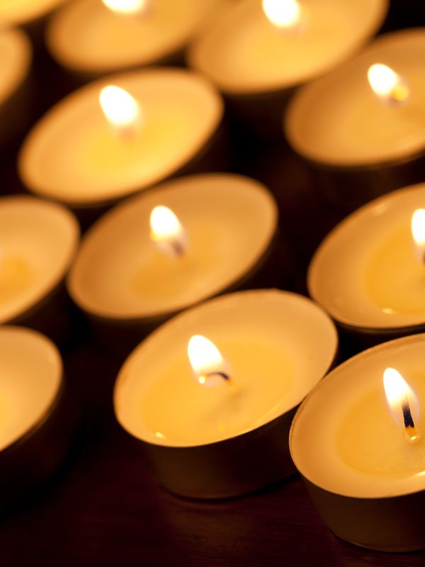 Close-up of several lit candles creating a warm glow.