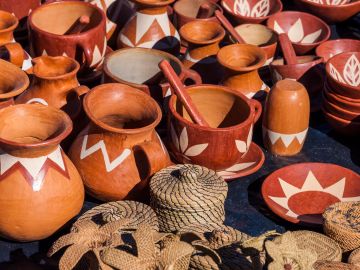 Handcrafted pottery with geometric designs and woven items.