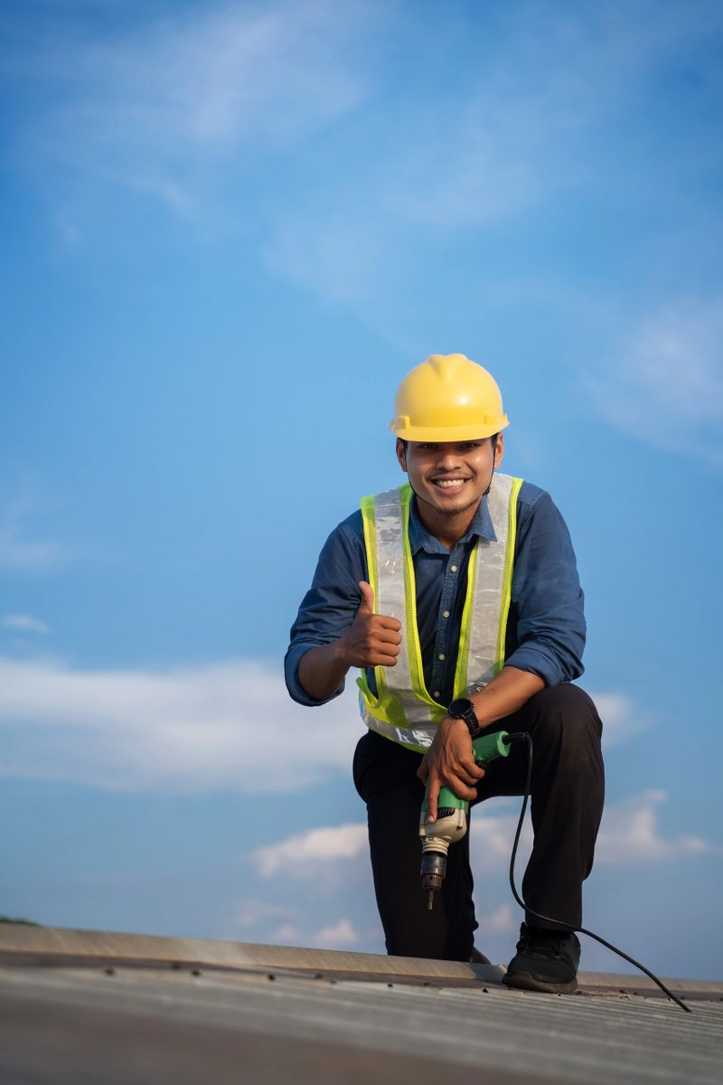 Worker repairing the roof on a construction site. Electric drill used on roof, Roof construction concept.