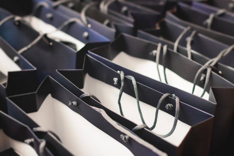 Corporate gifts and souvenirs for company employees, gift bag package for conference participants before start, presentation of corporate gifts, gift giving at office work, dark blue paper bag bunch