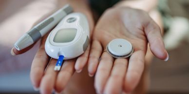 Medical devices for glucose monitoring held in hands.