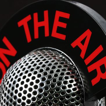 Close-up of a vintage microphone with 'ON THE AIR' sign.