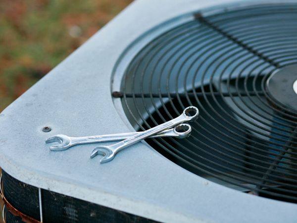 Wrenches on an air conditioning unit fan.