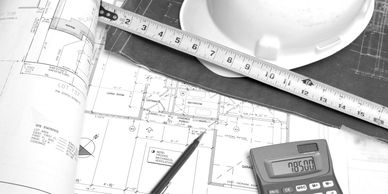 Architectural plans with tools and helmet.