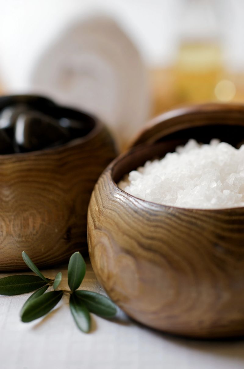 Bath salts, massage stones, and massage oil in a zen spa atmosphere.  