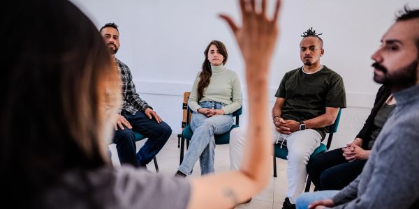 Group therapy session with one person speaking.