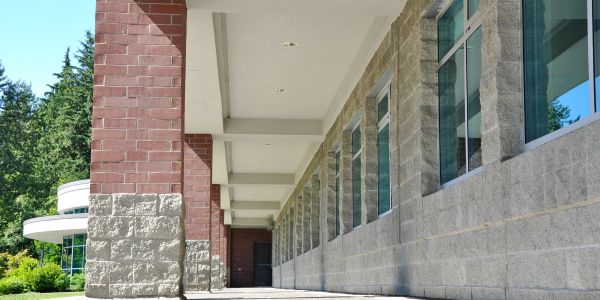 Outdoor walkway alongside a building with brick and stone walls.