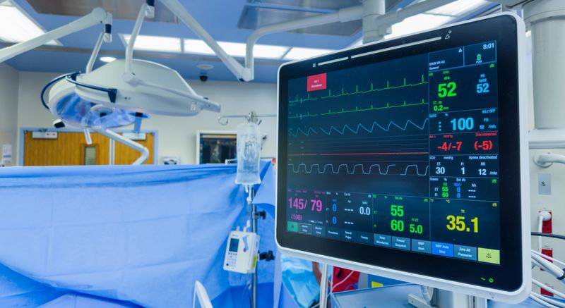 hospital monitor displaying vital signs: heart rate, blood pressure, temperature, and pulse oximetry, highlighting advanced medical technology in patient care