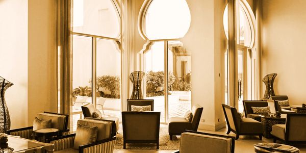 Elegant lounge area with large arched windows and comfortable seating.