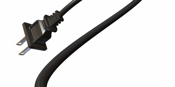 Black electrical power cord with plug on white background.