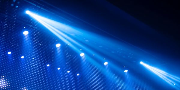 Bright blue stage lights illuminating a dark venue.