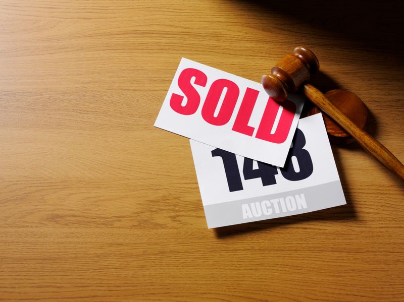 Red sold sign and auction paddle on a wooden desk with a gavel and block.Click on the link below to see more of my auction images.