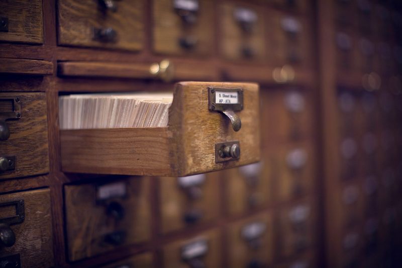 An antique card catalog drawer, open and ready. Horizontal with copy space.