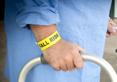 Person with fall risk wristband holding a walker.