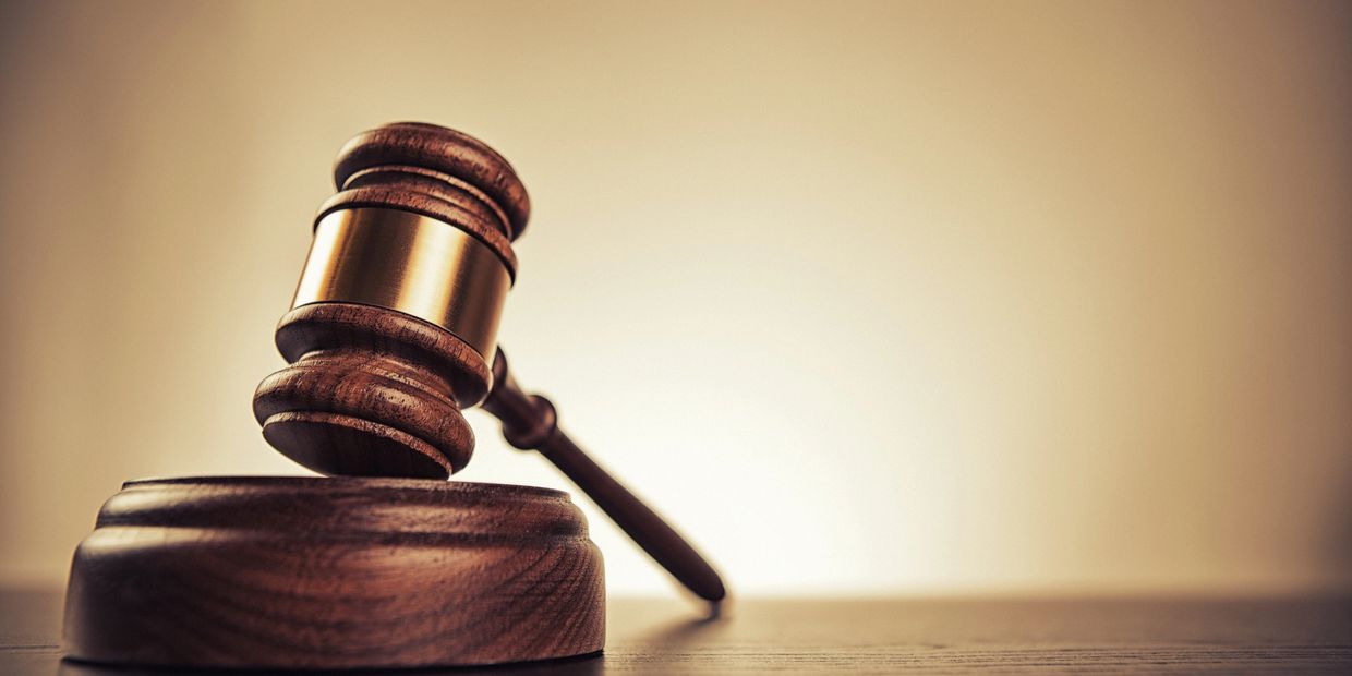 A wooden judge's gavel resting on its sound block.