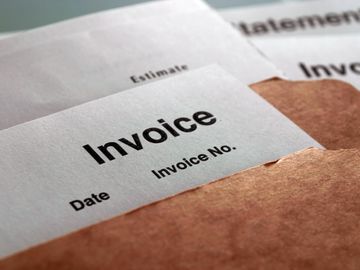 Close-up of an invoice document partially inside a brown envelope.