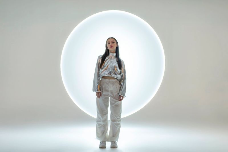 Young woman in front of a circular light shape.