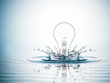 Light bulb splashing into water.