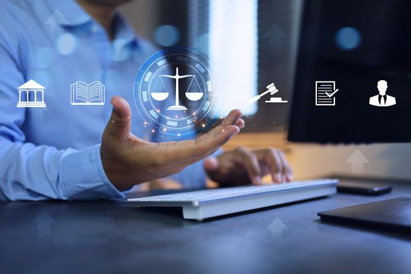 Person interacting with virtual legal icons over a keyboard.