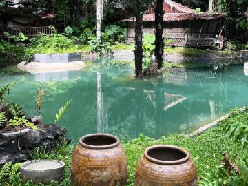 Peaceful garden pond with large ceramic pots.