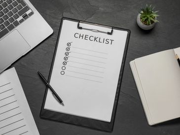 Checklist et carnet ouverts sur un bureau pour organiser les étapes clés d’une embauche.