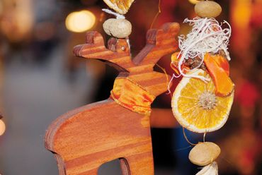 Wooden reindeer ornament with dried orange and nuts decoration.