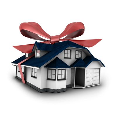 A house wrapped with a large red ribbon and bow like a gift.