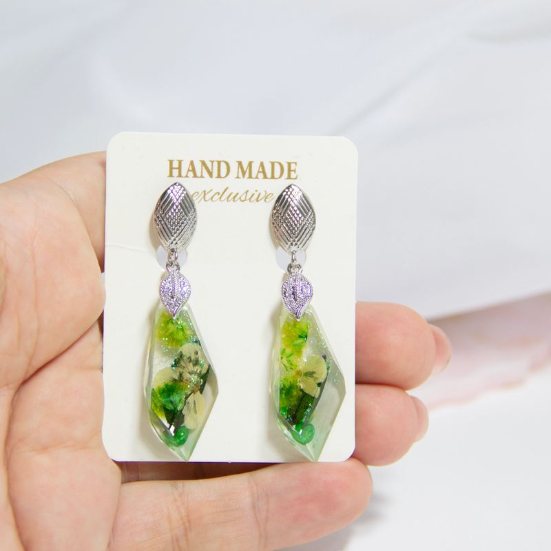 DIY costume jewelry made of epoxy resin and natural flowers, DIY jewelry master. Beautiful earrings and pendants made at home from jewelry resin.