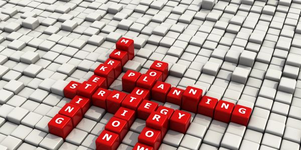 Red blocks with business strategy words form a crossword on white cubes.