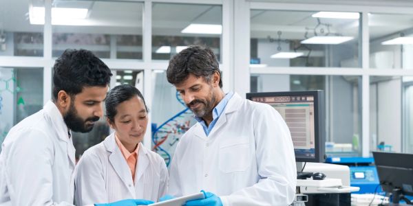 三名科学家在实验室讨论数据。
