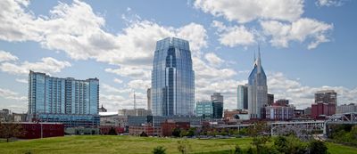 Skyline of a city with modern buildings under a partly cloudy sky.