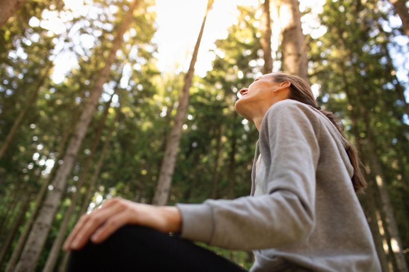 Young woman enjoying tranquil morning in the forest.