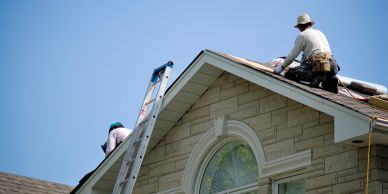 Two workers installing or repairing a roof.