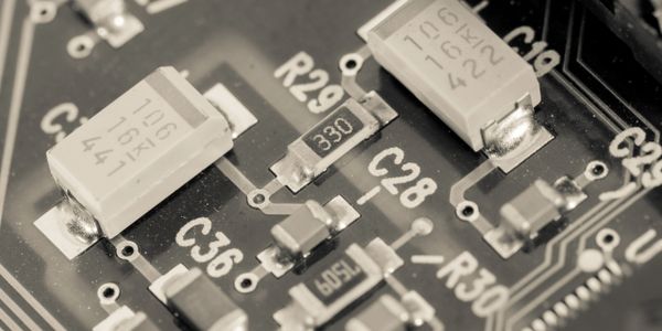 Close-up of electronic components on a circuit board showing resistors and capacitors.