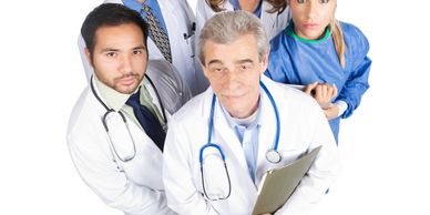 Five medical professionals looking up, dressed in lab coats and scrubs.