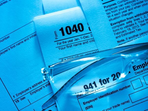 Close-up of U.S. tax forms with eyeglasses resting on them.
