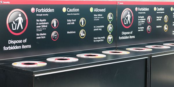 Airport security bins labeled for disposing forbidden liquids and blades. aviation security
security recruitment
security staff
