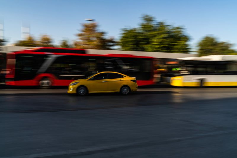 Long exposure view of urban public transportation vehicles on city roads. image of bus and commercial taxi in motion. Taken in daylight with a full frame camera.